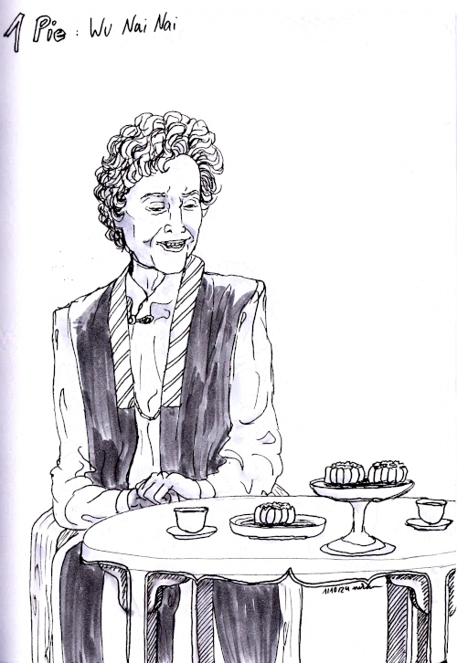 old woman in front of a table with mooncakes